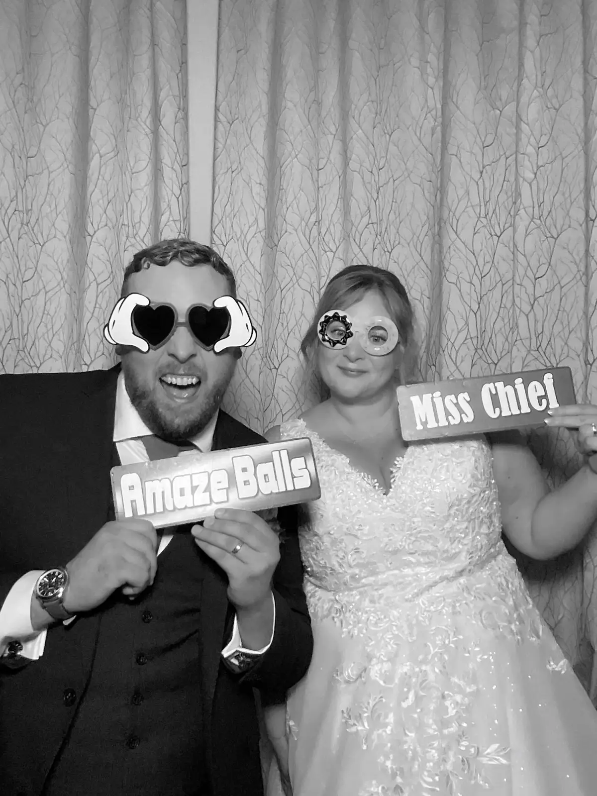 Wedding guests laughing in front of a vintage selfie pod with props
