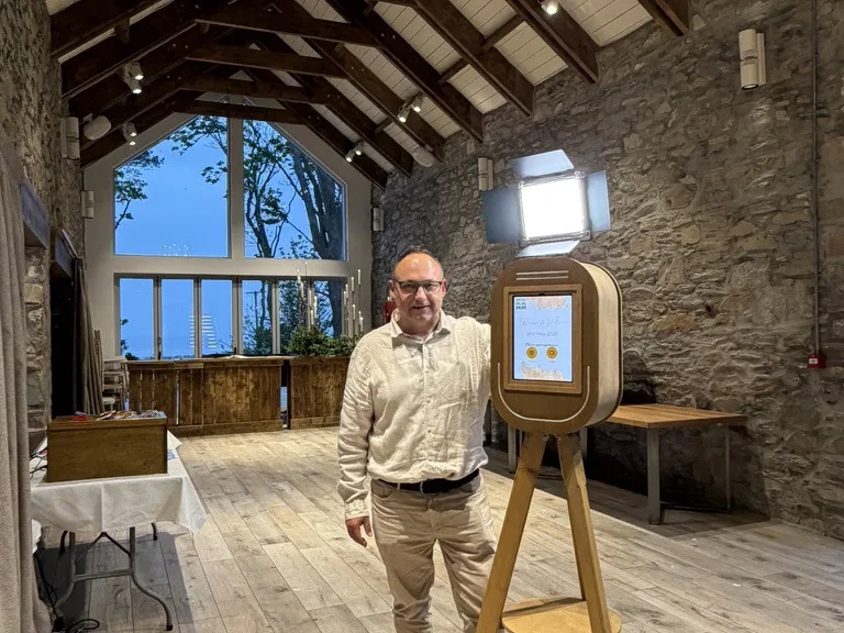 Andon — Funny Photo Booth Andon from Funny Photo Booth standing with the vintage selfie pod at a stone barn wedding venue